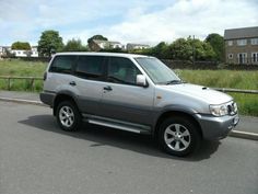 a silver suv is parked on the side of the road