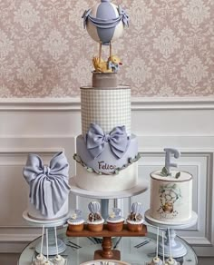 there are many different cakes and cupcakes on the cake stand, including one with a blue bow