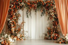 an orange and white wedding arch with flowers on the front, drapes in the back