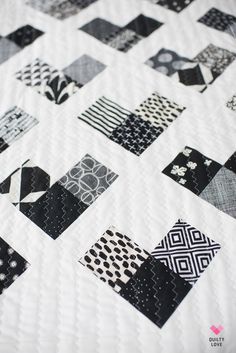 black and white patchwork quilt displayed on bed