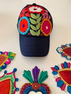 several embroidered items are laid out on a white surface, including a hat and sunglasses