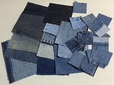 a pile of blue jeans sitting on top of a white table