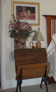 an old fashioned crib with a blanket on it in a bedroom next to a lamp