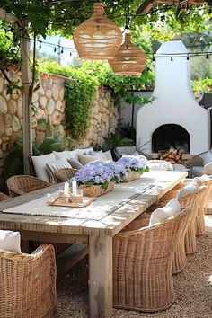 an outdoor dining area with wicker chairs and a wooden table surrounded by hanging lights