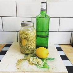 two jars filled with food sitting on top of a cutting board next to a lemon