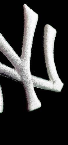 the letter k is made out of white yarn and has been stitched into it