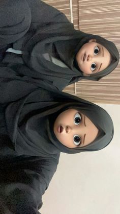 two dolls dressed in black standing next to each other