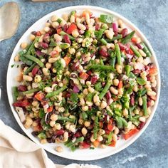 a white plate topped with beans and veggies on top of a blue table