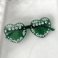 the green sunglasses are decorated with letters and numbers