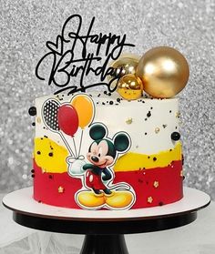 a mickey mouse birthday cake with balloons on top