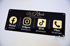 a black and gold business sign with different social media icons on the bottom half of it