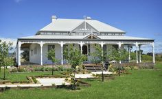 a white house sitting on top of a lush green field