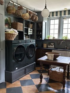 a laundry room with a checkered floor and black cabinets, baskets on the shelves