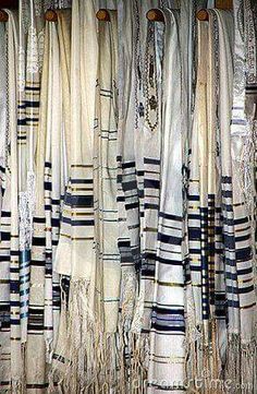 several rows of white and blue striped curtains hanging from hooks on the side of a wall