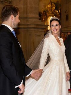 the bride and groom are holding hands