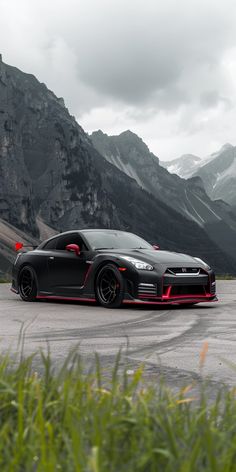 a black sports car parked in front of some mountains