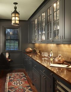 a kitchen with dark cabinets and wooden counter tops