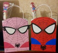 two paper bags with spiderman faces on them