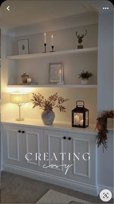 a white shelf with candles and flowers on it