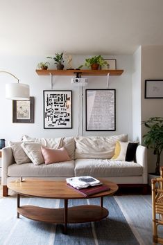 a living room filled with furniture and pictures on the wall above it's coffee table