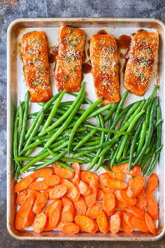 salmon, green beans and carrots on a baking sheet