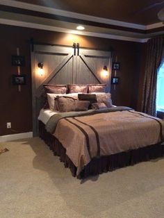 a large bed in a bedroom next to a window with lights on the headboard