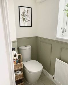 a white toilet sitting in a bathroom next to a radiator