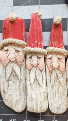 four wooden santas with red hats and beards