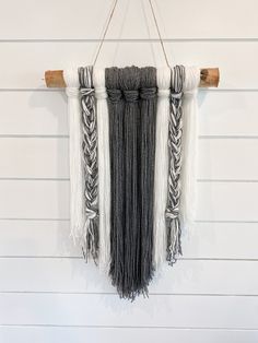 the wall hanging is decorated with different types of tassels and roped together