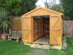 a wooden shed sitting in the middle of a yard