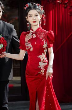 The dress adorned with a stunning phoenix print, adding an elegant, heritage-inspired aesthetic. The phoenix motif symbolizes prosperity and good fortune, making this gown a wonderful choice for special occasions. Whether you're looking for a showstopping wedding dress or a special event outfit, this red qipao offers the perfect fusion of time-honored Chinese craftsmanship and modern stylistic flair. Pair it with delicate accessories to create a refined look, or amp up the glamour with bold jewe Elegant Gown For Ceremony And Festivals, Elegant Red Ceremonial Dress, Red Brocade Wedding Dress, Traditional Red Cheongsam For Wedding, Short Sleeve Dresses For Wedding And Festivals, Traditional Red Wedding Cheongsam, Traditional Short Sleeve Cheongsam For Wedding, Traditional Embroidered Gown For Banquet, Elegant Dresses For Ceremonies And Festivals