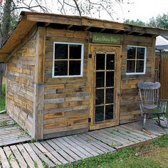 a small wooden shed sitting on top of a grass covered field