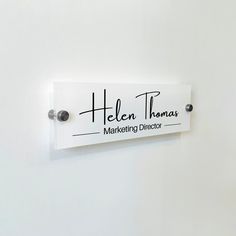 there is a sign on the wall that says helen thomas marketing director in black and white