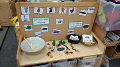 a wooden table topped with lots of toys and papers on it's back wall