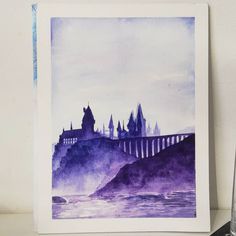 a watercolor painting of hogwarts castle in the fog with a glass next to it