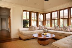 a living room filled with furniture and lots of windows