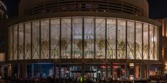 people are standing in front of a building at night