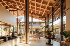 the inside of a building with lots of windows and plants in pots on the counter