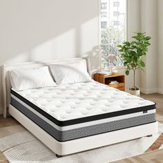 an image of a mattress in the middle of a room with white sheets and pillows