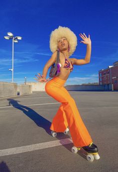 a woman in an orange outfit is on a skateboard outside with her arms outstretched