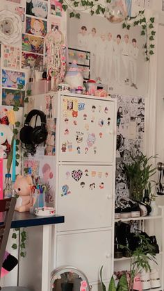 a refrigerator in a room with many pictures on the wall and plants growing out of it