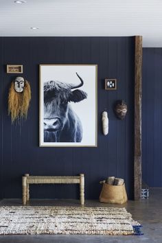 a living room with blue walls and pictures hanging on the wall, including a cow's head