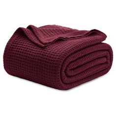 the burgundy blanket is folded and ready to be used