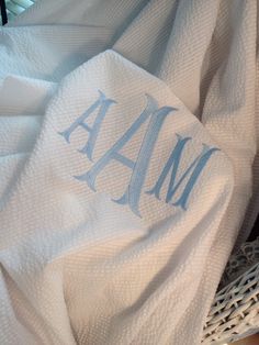 the monogrammed towels are on top of each other in a wicker basket