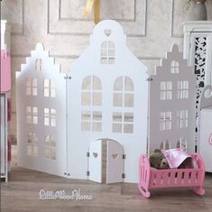 there is a doll house with pink furniture