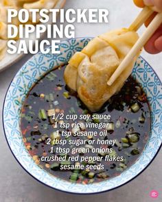 a person dipping sauce in a bowl with chopsticks to eat the dipper