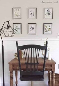 a chair sitting in front of a wooden desk with pictures on the wall behind it