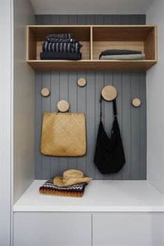 a coat rack with two purses and three hats on it, hanging from the wall