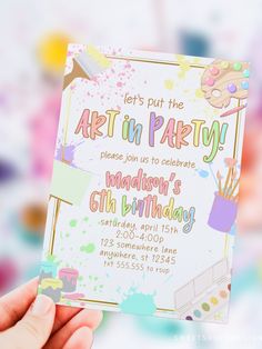 someone holding up a birthday party card with paint splatters on it and the text let's put the art in party please join us to celebrate madison's 6th birthday