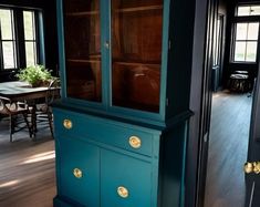 a blue china cabinet sitting in the middle of a room